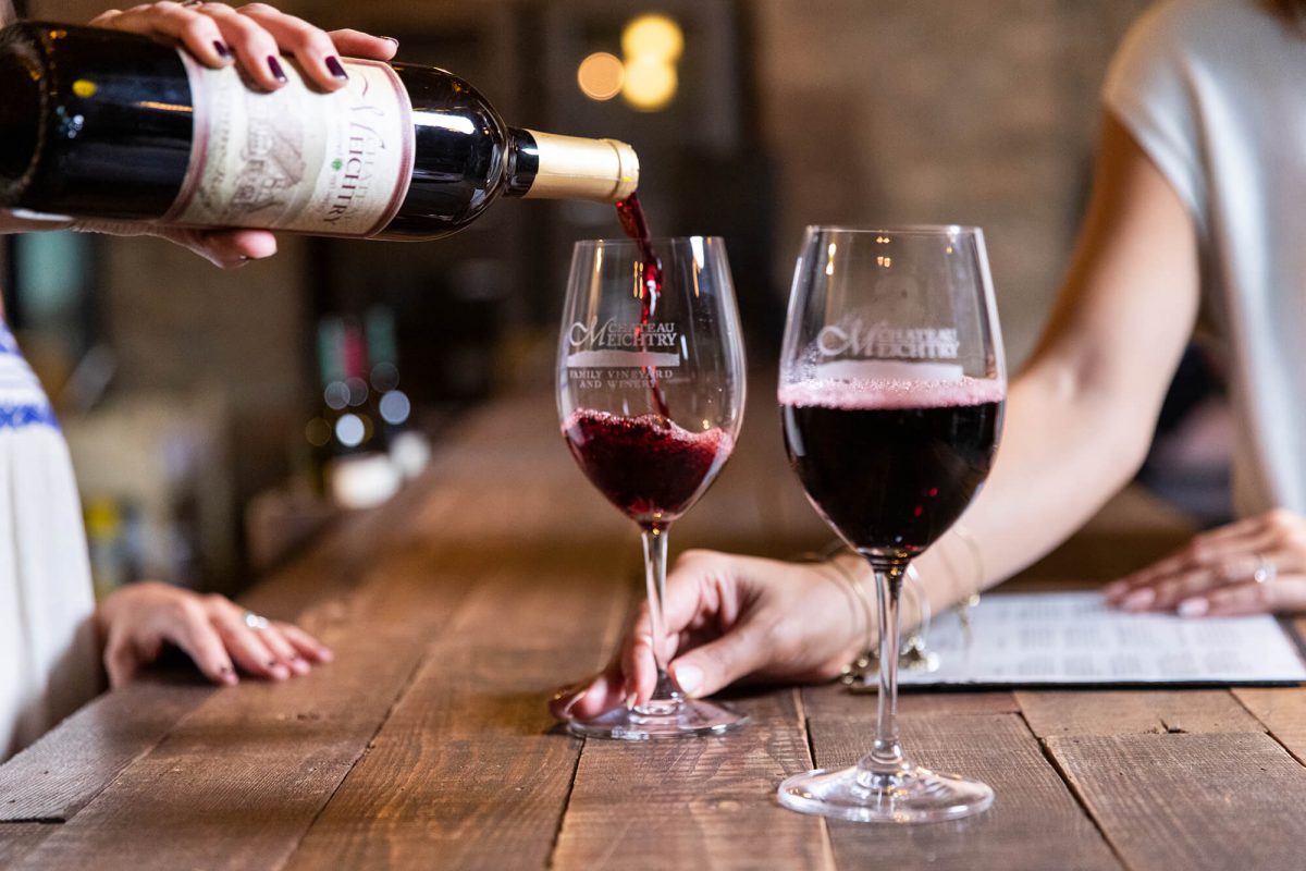 pouring red wine into wine glasses