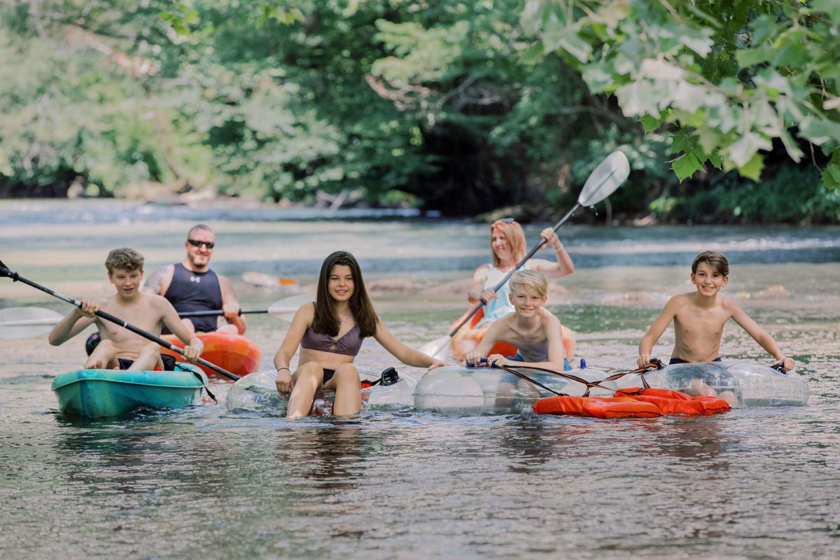 A family kayaking and tubing in a river