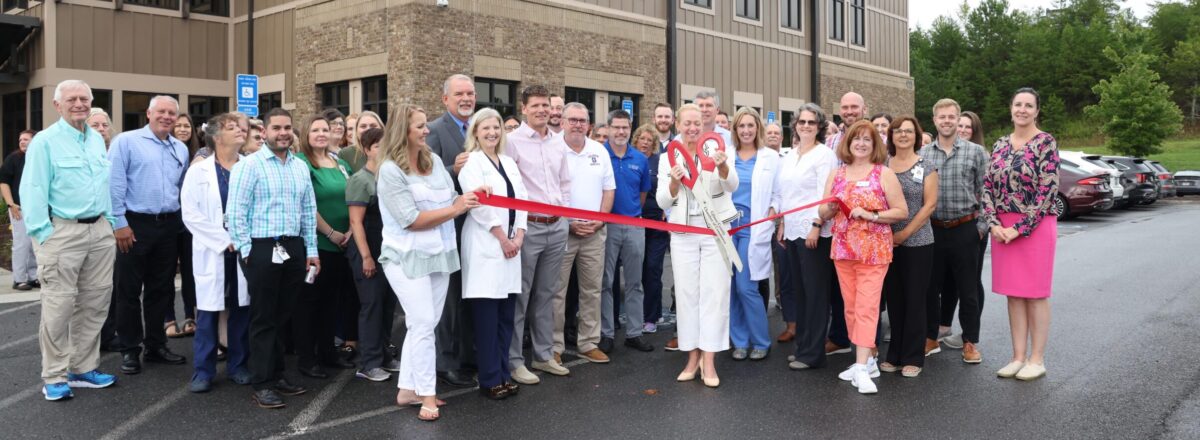 doctor cutting a ribbon with crowd